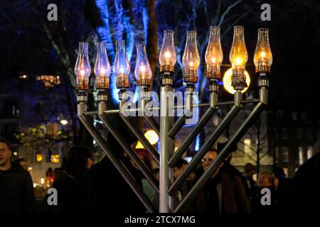 Londres, Royaume-Uni. 14 décembre 2023. Une menorah entièrement éclairée. Un événement de solidarité auquel ont participé des députés, des dirigeants communautaires et des membres du public a eu lieu après que la menorah a été vandalisée sur Islington Green plus tôt aujourd'hui. Rabbi Mendy Korer a dirigé les débats, reluisant les bougies - et la huitième et dernière pour le festival de Hanukkah. La police métropolitaine qui enquête, pense que la menorah a été intentionnellement endommagée, car les incidents antisémites augmentent depuis que la guerre Israël-Hamas a été déclarée. Crédit : Photographie de onzième heure / Alamy Live News Banque D'Images