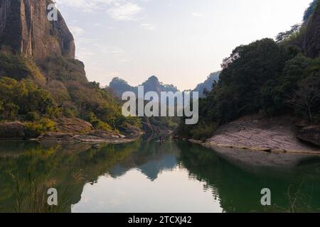 L'eau verte émeraude de la rivière Nine Bend ou de la rivière Jiuxi à travers Wuyishan ou le mont wuyi région pittoresque dans la province de Fujian en Chine. Arrière-plan du coucher du soleil Banque D'Images