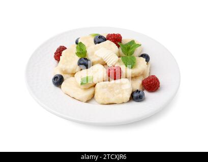 Assiette de délicieuses boulettes paresseuses avec des baies, des feuilles de menthe et du beurre isolé sur blanc Banque D'Images