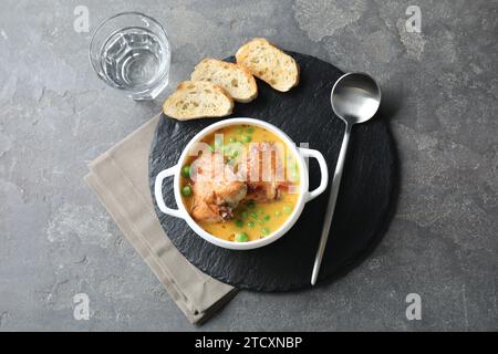 Savoureuse viande de lapin cuite avec sauce servie sur une table grise, vue de dessus Banque D'Images