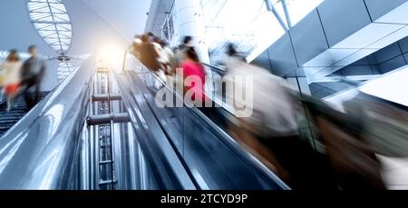 Les gens se précipitent sur le mouvement de l'escalier roulant flou Banque D'Images