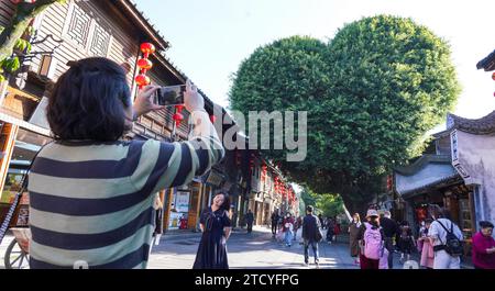 Un banian ressemblant à la forme d'un cœur à Sanfang Qixiang attire les touristes dans la ville de Fuzhou, dans la province du Fujian du sud-est de la Chine, le 14 décembre 2023. Banque D'Images