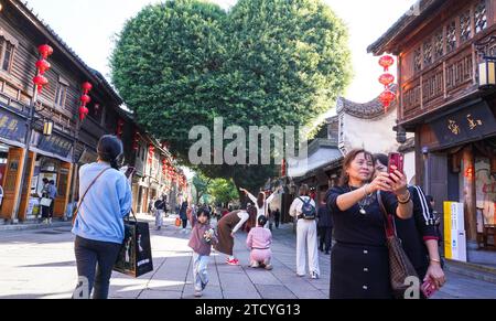Un banian ressemblant à la forme d'un cœur à Sanfang Qixiang attire les touristes dans la ville de Fuzhou, dans la province du Fujian du sud-est de la Chine, le 14 décembre 2023. Banque D'Images