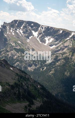 L'ombre et la lumière dansent à travers les montagnes enneigées et les forêts denses du parc national des montagnes Rocheuses, un témoignage de l'allure sauvage du parc. Banque D'Images