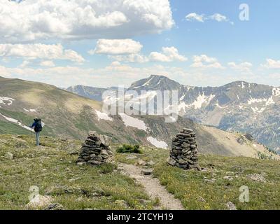 Un randonneur solitaire entre les guides de cairns admire la vaste étendue alpine le long de la North Inlet Trail dans le parc national des montagnes Rocheuses. Banque D'Images