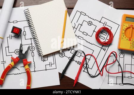 Composition à plat avec schémas de câblage et multimètre numérique sur table en bois Banque D'Images