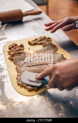 Baker faire du pain sucré farci. Pâte Babka avec garniture aux noix. Banque D'Images
