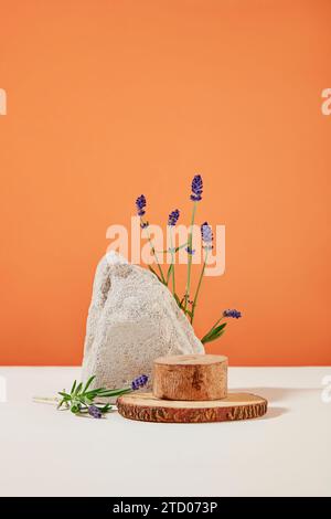 La plate-forme en bois et la dalle en pierre sont décorées de fleurs de lavande fraîches sur un fond blanc orange. Espace idéal pour afficher les produits contiennent Banque D'Images