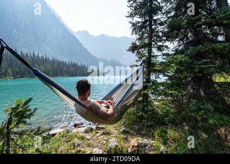 Randonneur admirant la vue tranquille sur le lac alpin Banque D'Images