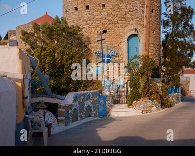 Île de Symi, Grèce - 20 avril 2023 : l'île de Symi est une petite île du Dodécanèse, qui étonne les visiteurs avec une atmosphère calme. Maisons néoclassiques colorées sur les collines de l'île pendant le coucher du soleil. Banque D'Images