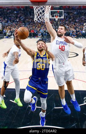 (231215) -- LOS ANGELES, 15 déc. 2023 (Xinhua) -- Stephen Curry (C) des Golden State Warriors va pour un lay-up lors du match de saison régulière de la NBA 2023-2024 entre les Clippers de Los Angeles et les Warriors de Golden State à Los Angeles, aux États-Unis, le 14 décembre 2023. (Photo de Ringo Chiu/Xinhua) crédit : Xinhua/Alamy Live News Banque D'Images