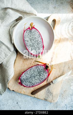 Tranché de fruits sur une assiette en céramique, affiché sur une planche à découper en bois rustique avec un couteau vintage. Banque D'Images