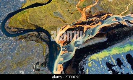 Une superbe prise de vue aérienne capturant les motifs sinueux des bassins fluviaux en Islande, avec des couleurs vives et des textures géologiques uniques Banque D'Images