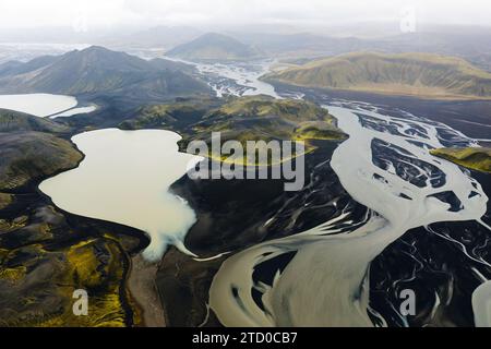 Une superbe photo aérienne capturant les motifs complexes et les couleurs vives des bassins fluviaux islandais juxtaposés à son terrain accidenté Banque D'Images