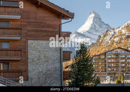 Une vue sereine du village de Zermatt présentant des bâtiments de style chalet avec l'emblématique montagne Matterhorn en arrière-plan. Banque D'Images