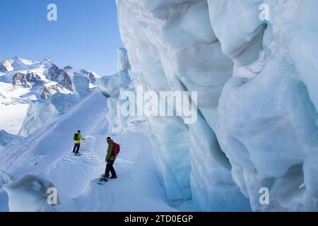 Angle élevé de randonneur anonyme avec sac à dos snowboard sur la montagne enneigée près des sommets glacés à Zermatt, Suisse avec un ami sous le ciel bleu Banque D'Images