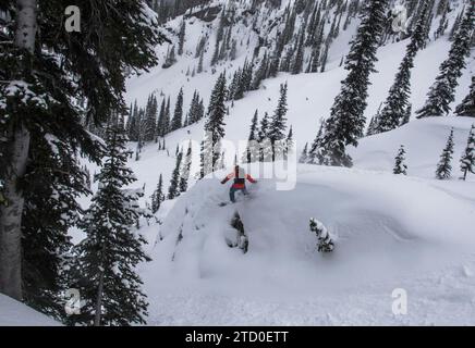 Vue de dessus du snowboarder anonyme descendant sur la majestueuse pente de montagne enneigée contre tout en profitant des vacances d'hiver au Canada Banque D'Images