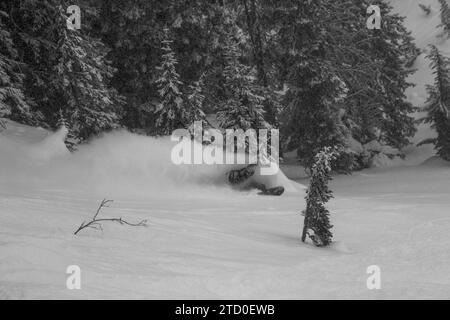 Vue de dessus d'un snowboardeur anonyme descendant sur une majestueuse pente de montagne enneigée tout en profitant de vacances d'hiver au Canada Banque D'Images