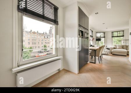 Fenêtre avec stores par des appareils modernes avec vue sur le salon et la salle à manger dans la maison spacieuse Banque D'Images