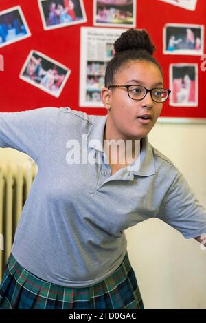 Les étudiants dans la salle de classe de théâtre répètent une performance pour un spectacle pour GCSE Drama Banque D'Images