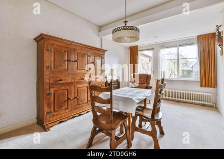 Nappe sur table en bois dans la salle à manger spacieuse de la maison moderne avec placard et fenêtre Banque D'Images