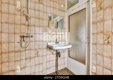 Douche en métal et lavabo dans la salle de bains moderne de la maison contemporaine avec mur carrelé et porte Banque D'Images