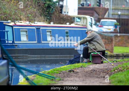 Stourbridge, Royaume-Uni. 15 décembre 2023. Météo britannique : c'est une matinée fraîche et ennuyeuse dans les Midlands, mais cela n'empêche pas les gens de sortir et de profiter de leur passe-temps préféré. Ce monsieur pêche un poisson, pêché sur le canal, lors d'une matinée tranquille de pêche, loin de l'agitation de la ville de Noël shopping. Crédit : Lee Hudson/Alamy Live News Banque D'Images