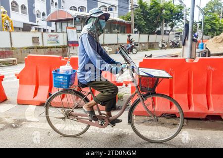 SAMUT PRAKAN, THAÏLANDE, septembre 30 2023, Un vendeur de loterie fait du vélo Banque D'Images