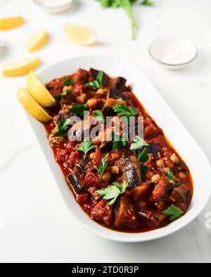 Maghmour ou moussaka libanaise. Plat à base d'aubergines cuites ou frites avec épices, pois chiches et sauce tomate. Les aubergines sont cuites dans de la sauce tomate Banque D'Images