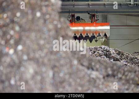 Décharge de combustible dérivé des déchets . Manutention et transport du combustible obtenu à partir de déchets (RDF) par grappin rouge à la chaudière pour combustion. Traitement de munic Banque D'Images