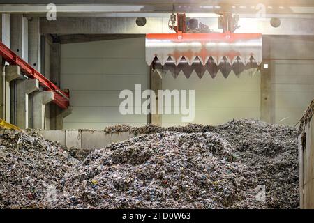 Décharge de combustible dérivé des déchets . Manutention et transport du combustible obtenu à partir de déchets (RDF) par grappin rouge à la chaudière pour combustion. Traitement de munic Banque D'Images