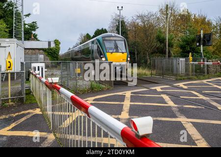 Train Irish Rail passant un passage à niveau dans le comté de Limerick, Irlande. Banque D'Images