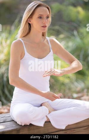 Femme pratique le yoga et médite dans la position du lotus Banque D'Images