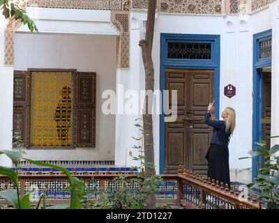 Les femmes touristes prennent une photo dans l'intérieur du Palais Bahia dans la ville de Marrakech aka Marrakech, Maroc. 15 décembre 2023 Banque D'Images