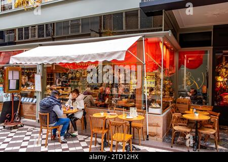 Un couple assis devant le Valentin Jouffroy, un beau café à l'intérieur du passage Jouffroy, une des galeries marchandes couvertes les plus populaires de Paris, Banque D'Images