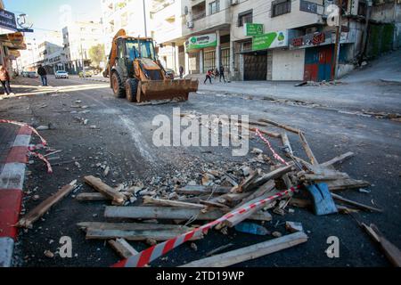 Un bulldozer palestinien enlève les décombres du site d'une frappe aérienne israélienne contre des militants palestiniens du camp de réfugiés de Balata, à l'est de la ville de Naplouse, en Cisjordanie. Un drone israélien a attaqué des militants palestiniens près de la tombe de Joseph pour tenter de les assassiner, et ils ont fui. Aucun blessé n'a été signalé et le raid a causé des destructions dans la rue. Banque D'Images