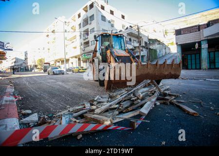 Un bulldozer palestinien enlève les décombres du site d'une frappe aérienne israélienne contre des militants palestiniens du camp de réfugiés de Balata, à l'est de la ville de Naplouse, en Cisjordanie. Un drone israélien a attaqué des militants palestiniens près de la tombe de Joseph pour tenter de les assassiner, et ils ont fui. Aucun blessé n'a été signalé et le raid a causé des destructions dans la rue. Banque D'Images