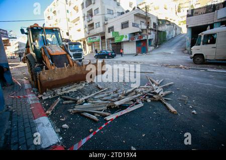 Un bulldozer palestinien enlève les décombres du site d'une frappe aérienne israélienne contre des militants palestiniens du camp de réfugiés de Balata, à l'est de la ville de Naplouse, en Cisjordanie. Un drone israélien a attaqué des militants palestiniens près de la tombe de Joseph pour tenter de les assassiner, et ils ont fui. Aucun blessé n'a été signalé et le raid a causé des destructions dans la rue. Banque D'Images