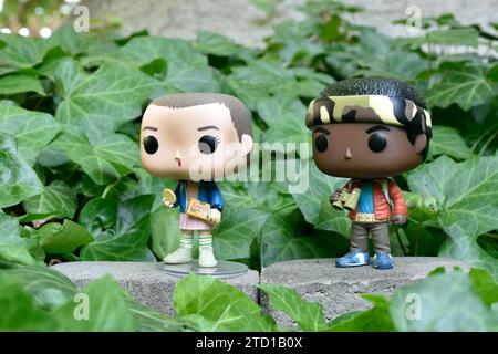 Figurines Funko Pop d'Eleven et Lucas de la série télévisée surnaturelle Netflix Stranger Things. Feuilles de lierre verte, jardin abandonné, amis. Banque D'Images