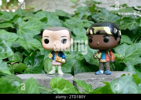 Figurines Funko Pop d'Eleven et Lucas de la série télévisée surnaturelle Netflix Stranger Things. Feuilles de lierre verte, jardin abandonné, amis. Banque D'Images