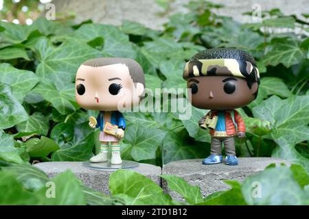 Figurines Funko Pop d'Eleven et Lucas de la série télévisée surnaturelle Netflix Stranger Things. Feuilles de lierre verte, jardin abandonné, amis. Banque D'Images