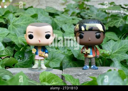 Figurines Funko Pop d'Eleven et Lucas de la série télévisée surnaturelle Netflix Stranger Things. Feuilles de lierre verte, jardin abandonné, amis. Banque D'Images