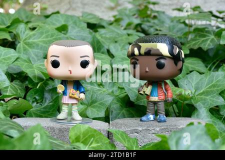 Figurines Funko Pop d'Eleven et Lucas de la série télévisée surnaturelle Netflix Stranger Things. Feuilles de lierre verte, jardin abandonné, amis. Banque D'Images