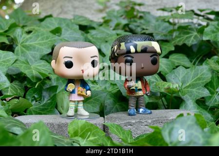 Figurines Funko Pop d'Eleven et Lucas de la série télévisée surnaturelle Netflix Stranger Things. Feuilles de lierre verte, jardin abandonné, amis. Banque D'Images