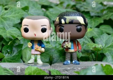 Figurines Funko Pop d'Eleven et Lucas de la série télévisée surnaturelle Netflix Stranger Things. Feuilles de lierre verte, jardin abandonné, amis. Banque D'Images