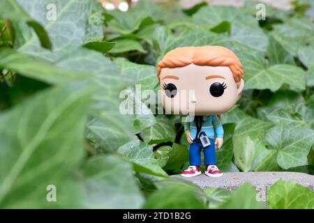 Funko Pop figurine d'action de Max Mayfield avec lecteur de cassette de la série télévisée Netflix Stranger Things. Feuilles de lierre verte, jardin abandonné. Banque D'Images