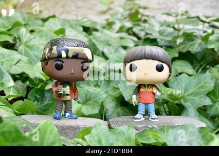 Funko Pop figurines de Lucas et Will de Netflix Supernatural série télévisée Stranger Things. Feuilles de lierre verte, jardin abandonné, amis. Banque D'Images