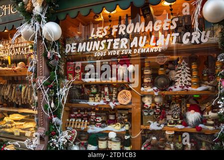 Ribeauville, France - 25 décembre 2022 : vitrine de boutique de spécialités culinaires décorée pour Noël. Charcuteries locales et fameux fromage Munster alsacien Banque D'Images