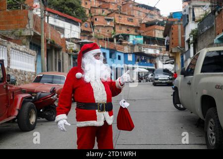 Caracas, Venezuela. 15 décembre 2023. 15 décembre 2023, Venezuela, Caracas : un homme habillé en Père Noël marche dans une ruelle dans le quartier pauvre de Petare lors de la remise de la campagne de cadeau «Un jouet, de bonnes nouvelles». Photo : Pedro Mattey/dpa crédit : dpa Picture alliance/Alamy Live News Banque D'Images