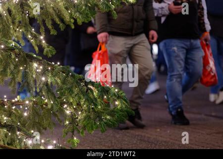 PRODUCTION - 15 décembre 2023, Rhénanie du Nord-Westphalie, Cologne : deux hommes portant des sacs dans la zone piétonne de Schildergasse. Photo : Henning Kaiser/dpa Banque D'Images